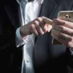 Is Outsourcing Your PPC Really a Win-Win-Win Situation? Man holding a phone