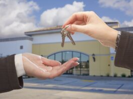 How A Mortgage Broker Can Help When Buying Business Property Real Estate Agent Handing Over the Keys in Front of Vacant Business Office.