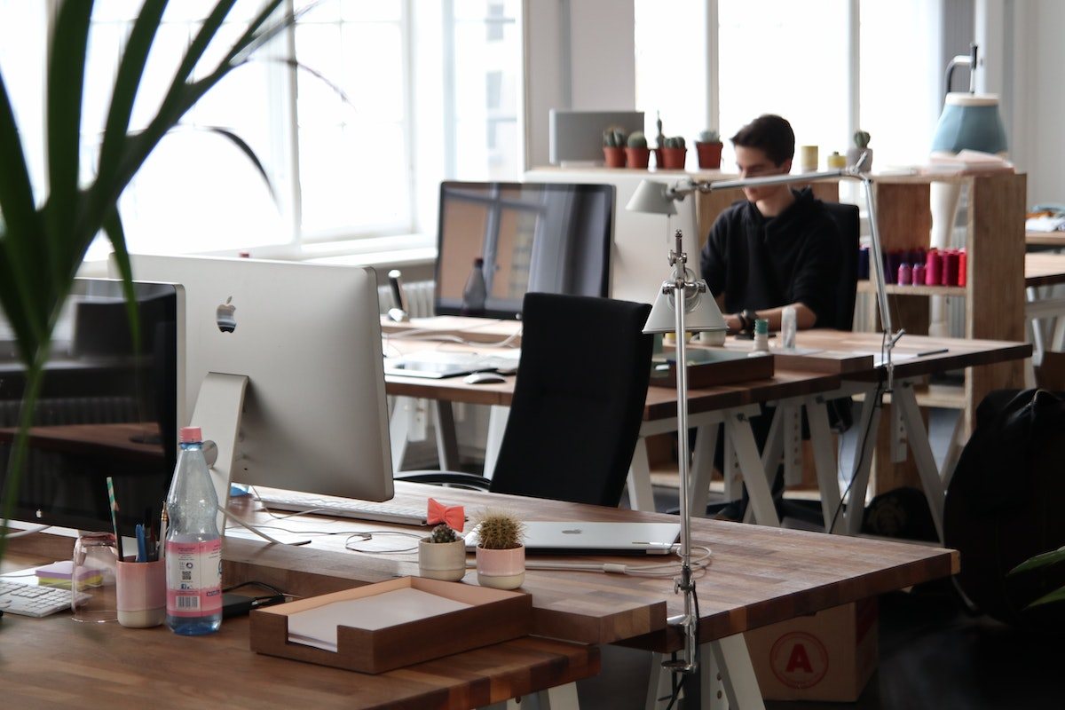 a man working in an office next to a window