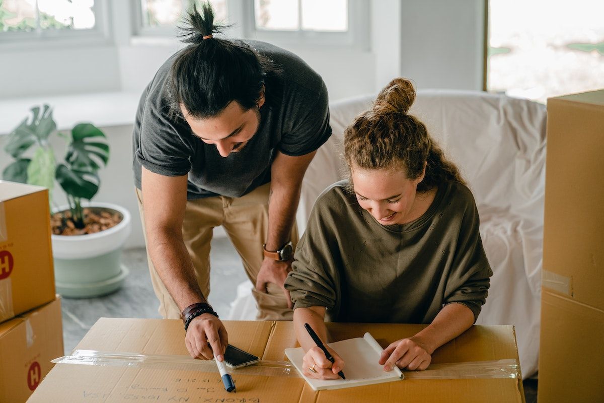 a woman and a man talking while packing