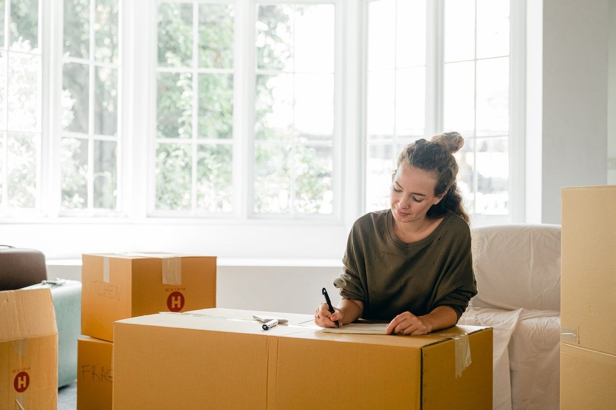 a woman making an inventory list while packing