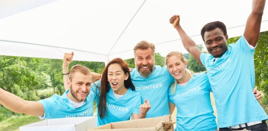 A Business’s Complete Guide To Non-Profit Fundraising Volunteer volunteers cheer at a charitable fundraiser